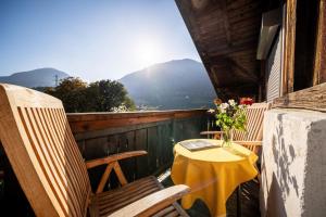 a table and chairs on the balcony of a house at Pool Apartments Edith in Lana +50 photos