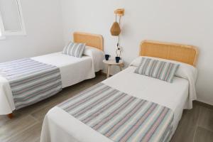 a hotel room with two beds and a table at Villa 10 Marias in Cala Blanca