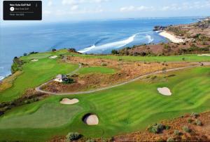 an aerial view of a golf course with the ocean at NiMo Bamboo in Jimbaran