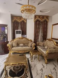 a living room with gold furniture and a chandelier at 3 bed room flat and 2 toilet in Benin City