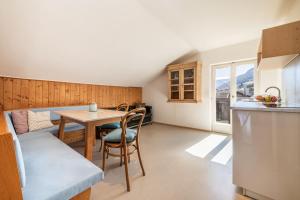 a kitchen and a dining room with a table and a counter at Pool Apartments Edith in Lana