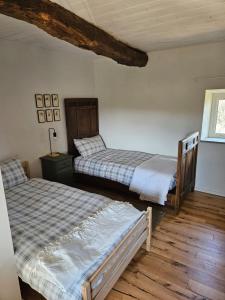 two beds in a room with wooden floors at Casa Mondonio in Castelnuovo Don Bosco
