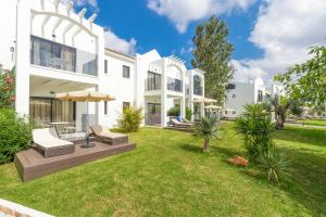 a large white house with a yard at MarSenses Paradise Club in Cala en Bosc