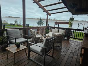 um deque com cadeiras e uma mesa com vista para a água em Lulu's Glamping Tents and Events with Exceptional River View em Palmer