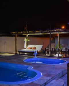 a pool in the middle of a patio at night at Aruna Eco Pousada in Búzios
