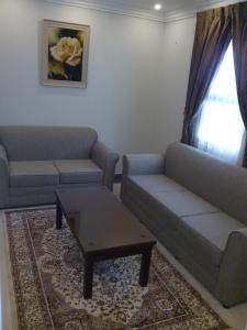 شقق برج نوران للشقق المخدومة في الجبيل: غرفة معيشة مع أريكة وطاولة قهوة