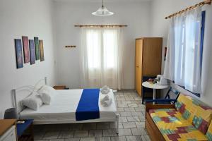 a bedroom with a bed and a couch in it at Villa Dolphin in Azolimnos Syros