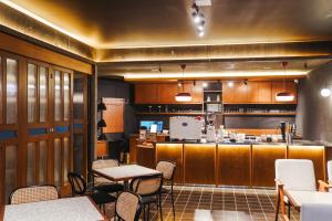 a restaurant with tables and chairs and a kitchen at Tanawana Borobudur Living in Kembanglimus