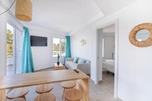 a living room with a table and a couch at MarSenses Ferrera Blanca Hotel Family in Cala d´Or