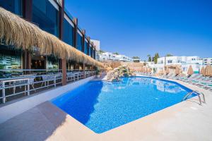 a large swimming pool with chairs and a building at MarSenses Ferrera Blanca Hotel - Adults Only in Cala d´Or