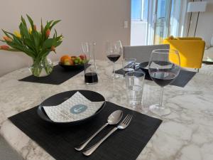 a table with glasses of wine and silverware on it at Panoramablick Ostsee, Binnensee & Salzwiesen - Balkon - Stilvoll - Highspeed Glasfaser WLAN - Parkplatz - Ferienwohnung 'Freiheit' in Heiligenhafen