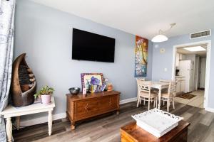 un soggiorno con tavolo e TV a parete di Oceanfront with Lazy River and Huge Pool Oasis a Myrtle Beach Altre 37 foto