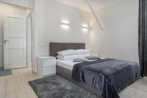 a white bedroom with a bed and a white door at 11B Svečių namai Palanga in Palanga
