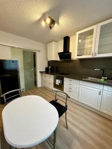 a kitchen with a white table and a white counter top at Apartment Rose in Bad Rappenau