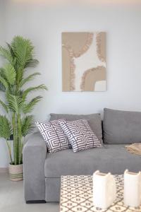 ein Wohnzimmer mit einer grauen Couch mit zwei Kissen in der Unterkunft Petrino Complex Pefkohori by Halkidiki Villas in Pefkohori