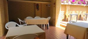 un ristorante con tavoli e sedie bianche e un patio di Assinie Lodges a Assinie