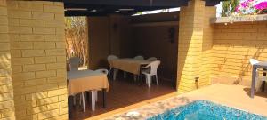 un patio con tavoli, sedie e piscina di Assinie Lodges a Assinie
