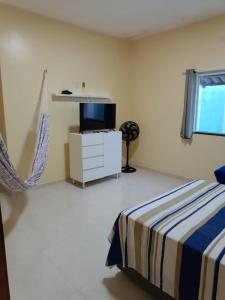 a bedroom with a bed and a tv on a dresser at Nova casa de praia na Caponga in Cascavel