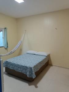 a bedroom with a bed in a white room at Nova casa de praia na Caponga in Cascavel