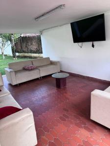 a living room with a couch and a flat screen tv at Finca Luciana in Jamundí