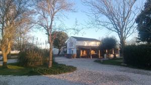 a white house with trees in front of it at Mas Constantin in Salin-de-Giraud