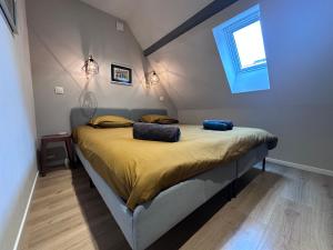 a bedroom with a bed with yellow sheets and a window at B'm Gretel - Duplex 4 pers - Vue Cathédrale - Centre Historique in Colmar +11 photos
