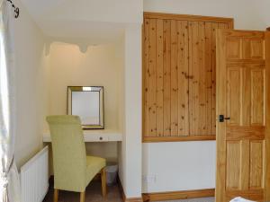 a room with a chair and a mirror and a door at Brackendale Cottage - Uk1335 in Threlkeld +9 photos