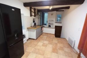 マントンにあるVieille ville Menton-ideale invernoのタイルフロアのキッチン(黒い冷蔵庫付) +2枚の写真