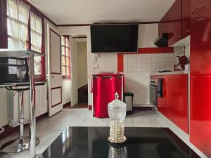 a kitchen with red appliances and a red refrigerator at Petit Duplex in Honfleur