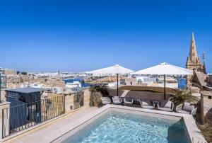 a swimming pool on a balcony with a view of the city at Old Theatre Suites - Montecristo in Valletta