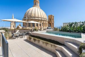a building with a pool and a building with a dome at Old Theatre Suites - Montecristo in Valletta