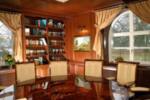 a dining room with a table and chairs and book shelves at Seeschloss Schorssow in Schorssow