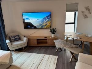 a living room with a flat screen tv on a wall at Hightide luxury seaside apartment in Exmouth