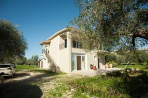a white house with a car parked in front of it at Panagis Apartments in Argostoli
