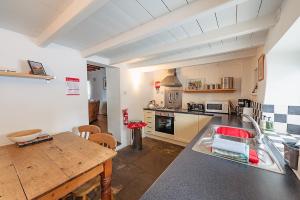 a kitchen with a wooden table and a counter top at The Bolthole, Leyburn in Leyburn
