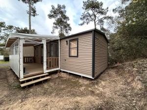 a tiny house with a porch and a gazebo at Le Domaine des Pins in Saint-Hilaire-de-Riez