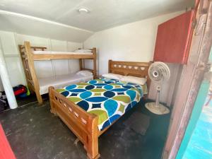 - une chambre avec des lits superposés et un ventilateur dans l'établissement Hostal Doña Aura, à Tintipan Island