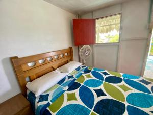 - une chambre avec un lit doté d'une couette bleue et verte dans l'établissement Hostal Doña Aura, à Tintipan Island
