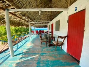 une table et des chaises sur la terrasse d'un restaurant dans l'établissement Hostal Doña Aura, à Tintipan Island