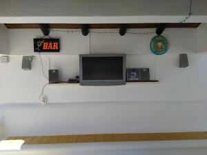 a room with a tv and a clock on the wall at Guesthouse Vista dos Cerros in Loulé