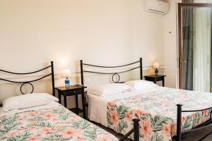 two beds sitting next to each other in a bedroom at Agriturismo Santa Lucia in Fonteblanda
