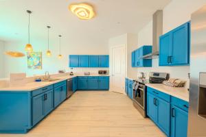 a blue kitchen with white counters and blue cabinets at Palm Paradise in South Padre Island