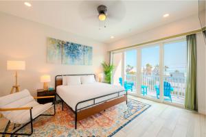 a bedroom with a bed and a balcony at Palm Paradise in South Padre Island