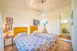 a bedroom with a bed with a blue and white comforter at Casa Peronospora by Kompas Villas in Čepljani +29 photos