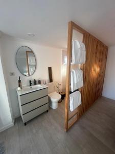 un bagno con lavandino, WC e specchio di Casa aroeira a Aroeira