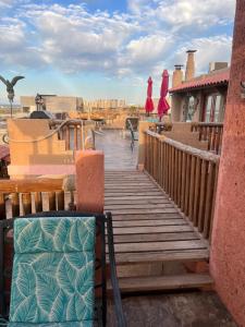 una terraza de madera con sillas y sombrillas en una casa en No bad days loft Artisans Dream, en Puerto Peñasco