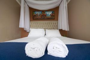 a bedroom with a bed with towels on it at Happiness House Hospedagem in Cuiabá +16 photos