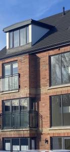 a brick building with a balcony on the side of it at Belfast city stylish spacious apartment great location free parking in Belfast