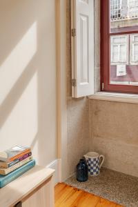 Zimmer mit einem Schreibtisch mit Büchern und einem Fenster in der Unterkunft Visconde de Gandara Apartment by Porto Stories in Porto + 37 Fotos