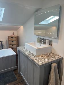 ein Badezimmer mit Waschbecken und Spiegel in der Unterkunft Bramble Cottage on the edge of Exmoor in Combe Martin + 42 Fotos